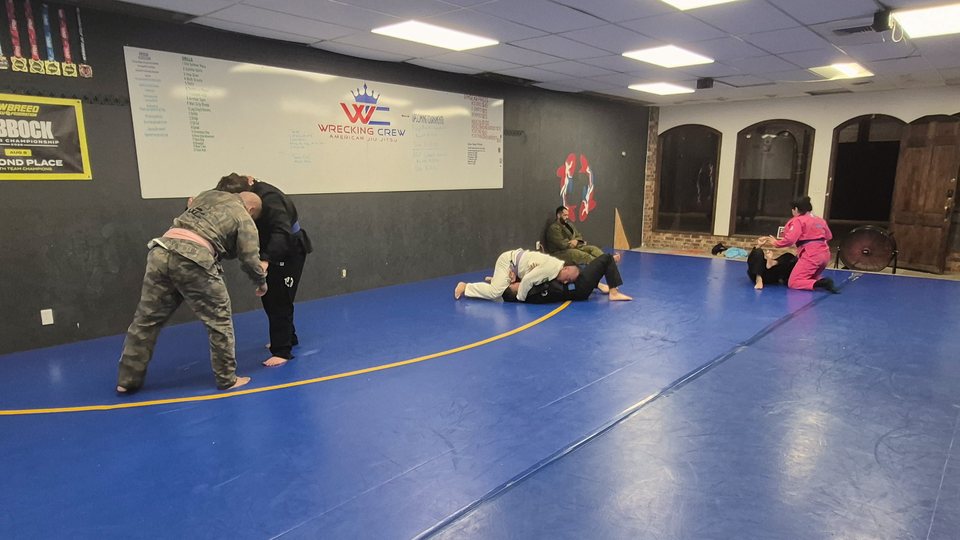 Training partners practicing across the blue mats at Wrecking Crew.